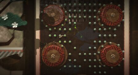 Toggle swinging across rotating wheels. Official screenshot from the LittleBigPlanet Twitter account.[1]