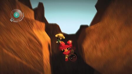 A screenshot of a player dragging Luchador down a pit. Official screenshot from the LittleBigPlanet Website.