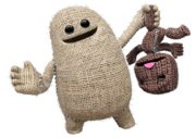 Big Toggle holding Sackboy upside-down.